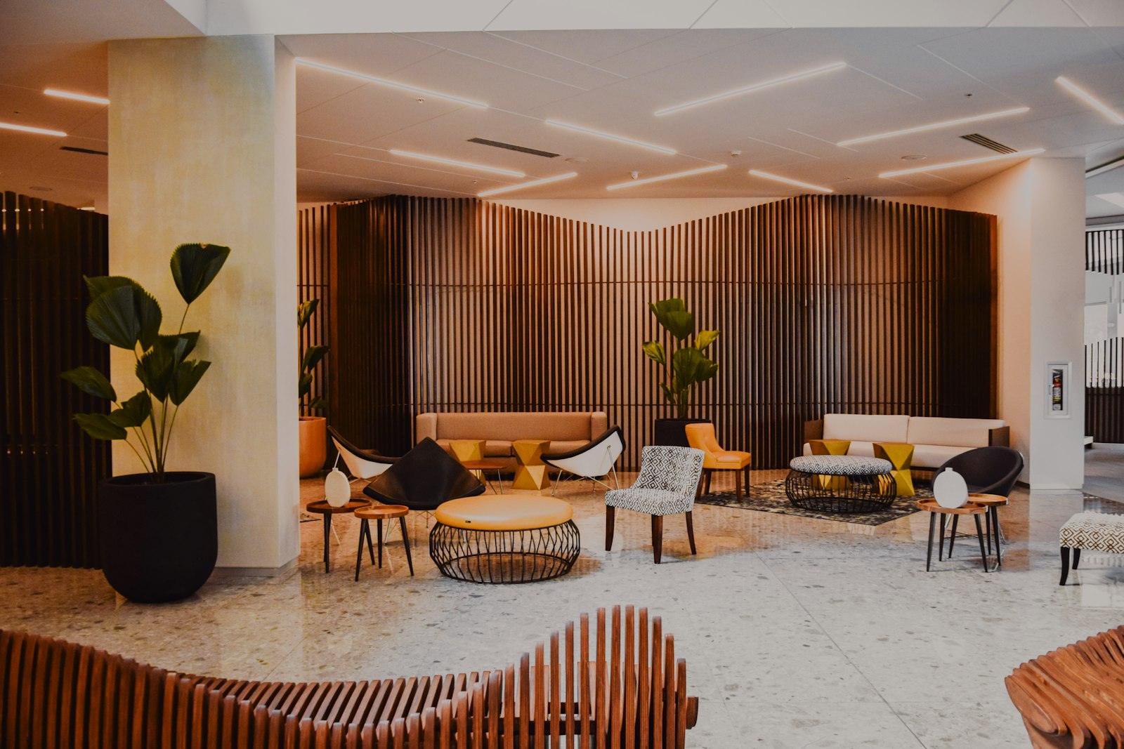 A modern hotel lobby with wood paneling and lounge seating