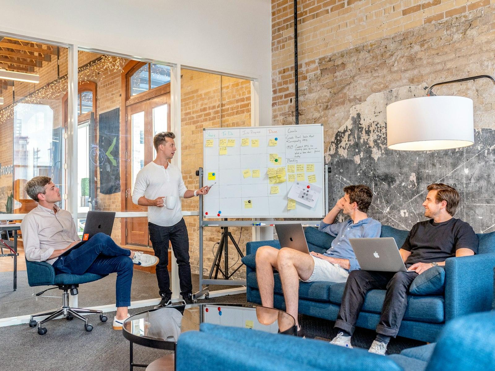 A startup team gathered around a whiteboard in an open office
