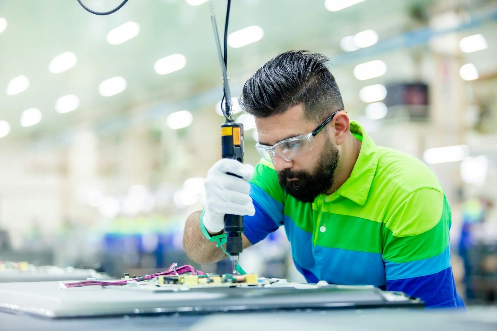 A technician assembling a component on a production line