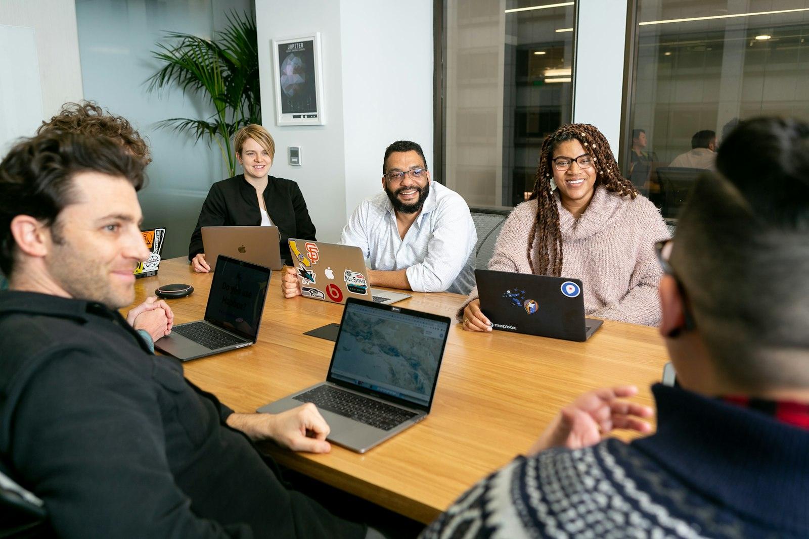 A startup team meeting around a table with laptops